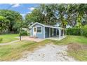 View of the house with blue siding and a yellow door and covered parking space on the side at 3608 Water St, Ellenton, FL 34222