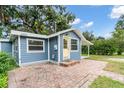 Adorable blue home showcasing a vibrant yellow front door and brick landing at 3608 Water St, Ellenton, FL 34222