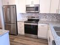 Modern kitchen with stainless steel appliances, including a refrigerator, microwave, oven, and sleek granite countertops at 3744 Lake Bayshore Dr # K-503, Bradenton, FL 34205