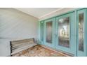 Stylish front door with decorative glass, complemented by a bench and stone patio at 3761 Countryside Rd, Sarasota, FL 34233