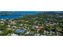 Aerial view of the property and the surrounding wooded neighborhood close to the water at 4307 Camino Real, Sarasota, FL 34231