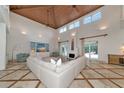 Spacious living room boasts soaring ceilings, travertine floors, and a cozy fireplace at 4307 Camino Real, Sarasota, FL 34231