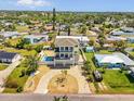 Aerial view of a charming home with a pool, driveway, and mature landscaping in a friendly neighborhood at 4717 Lemon Bay Dr, Venice, FL 34293