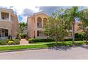 Charming two-story townhome with a quaint balcony, surrounded by mature trees and well-maintained landscaping at 5388 Davini St, Sarasota, FL 34238