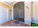 Close-up of the front entryway featuring a decorative security gate and brick paver walkway at 585 Khyber Ln, Venice, FL 34293