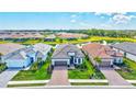 An aerial view of three homes and their manicured lawns, set against a serene backdrop of a community lake at 6203 Grandview Hill Ct, Bradenton, FL 34203