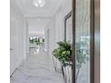 The light-filled foyer features gleaming marble floors and decorative mirror, creating an elegant and welcoming entrance at 6203 Grandview Hill Ct, Bradenton, FL 34203