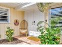Close-up of the double front door featuring a cozy chair and tropical accents at 6343 Hollywood Blvd, Sarasota, FL 34231