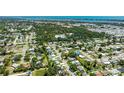 Wide aerial view of a neighborhood with mature trees and the coastline visible in the distance at 6529 Seagate Ave, Sarasota, FL 34231