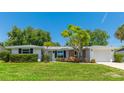 Inviting single-story home featuring a lush green lawn and mature landscaping in a quiet neighborhood at 6529 Seagate Ave, Sarasota, FL 34231