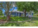 Inviting single-story home featuring mature trees and lush landscaping enhancing its curb appeal at 6605 253Rd St E, Myakka City, FL 34251