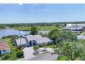 Expansive property featuring manicured landscaping, a serene lake view, and a beautiful light gray tiled roof at 6702 Drewrys Blf, Bradenton, FL 34203