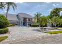 Beautiful single-story home with manicured landscaping, water feature, and long paver driveway at 6702 Drewrys Blf, Bradenton, FL 34203