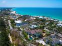Breathtaking aerial view of a home with a pool, surrounded by lush greenery and the ocean nearby at 7333 Point Of Rocks Rd, Sarasota, FL 34242