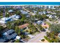 This aerial view showcases the property's proximity to the beach, surrounded by lush trees in a vibrant neighborhood at 734 Canal Rd, Sarasota, FL 34242