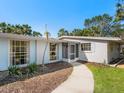 A inviting entrance featuring a quaint walkway, screened doorway, and light blue window accents at 734 Canal Rd, Sarasota, FL 34242