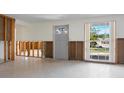 Spacious living room features a large window, with open wall studs for remodeling at 734 Canal Rd, Sarasota, FL 34242