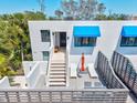 A private outdoor balcony features modern outdoor furniture and a peek of the entrance below at 750 Bayport Way # 750, Longboat Key, FL 34228