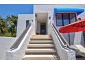 Staircase leading to unit entrance with a charming blue awning and red umbrella at 750 Bayport Way # 750, Longboat Key, FL 34228