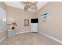 Neutral bedroom featuring tile floors, beach painting, and a ceiling fan at 7624 Boltons Ct, Bradenton, FL 34201