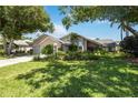 Charming one-story home with lush landscaping, mature trees, and a well-manicured lawn at 8142 Misty Oaks Blvd, Sarasota, FL 34243