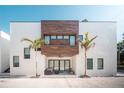 Stunning modern home featuring a minimalist design with a private outdoor seating area and palm tree landscaping at 816 Goodrich Ave, Sarasota, FL 34236