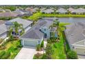 Aerial view of home showcasing lush landscaping, a lake, and a well-maintained yard at 12330 Halfmoon Lake Ter, Bradenton, FL 34211