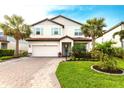 Inviting two-story home featuring a beautiful brick driveway, a two-car garage, and lush landscaping at 13422 Flat Woods Ter, Bradenton, FL 34211