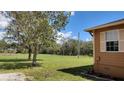 Expansive grassy yard with mature trees bordering the property, offering privacy and a natural setting at 15308 Fruitville Rd, Sarasota, FL 34240
