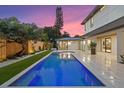 Modern pool with integrated spa, framed by manicured landscaping and a contemporary home design at 1559 Bay Rd, Sarasota, FL 34239