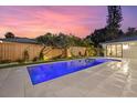 Stunning pool with inset spa, complemented by lush landscaping and privacy fence at 1559 Bay Rd, Sarasota, FL 34239