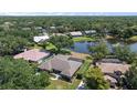 Aerial view of the property showcasing the home's proximity to a serene pond and lush trees at 1661 Cottonwood Trl, Sarasota, FL 34232
