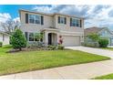 Well-manicured lawn and garden beds accent this two-story home with a two-car garage and concrete driveway at 17124 Harvest Moon Way, Lakewood Ranch, FL 34211