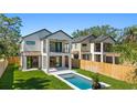 Back of house featuring pool, lawn, second-story balcony, and modern design at 2249 Oak Terrace Ter, Sarasota, FL 34231