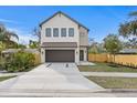 Modern two-story home featuring a neutral color scheme, a dark two-car garage door, and a well-manicured lawn at 2554 Arlington St, Sarasota, FL 34239