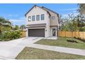 Modern two-story home featuring a neutral color scheme, a dark two-car garage door, and a well-manicured lawn at 2554 Arlington St, Sarasota, FL 34239