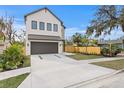 Modern two-story home featuring a neutral color scheme, a dark two-car garage door, and a well-manicured lawn at 2554 Arlington St, Sarasota, FL 34239