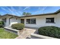 Inviting front entrance with manicured bushes and a stone-paved walkway to the door at 2702 Bedford Way, Sarasota, FL 34239