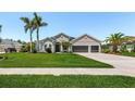 Charming single-Gathering home with manicured lawn, mature palm trees, and a three-car garage at 3015 160Th E Ter, Parrish, FL 34219