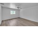 Cozy bedroom with wood-look flooring, a ceiling fan, a window, and neutral-colored walls at 3204 Pericles Ave, North Port, FL 34286