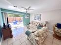 Bright living room with tile floors, ceiling fan, and sliding glass doors to a patio at 3473 Clark Rd # 171, Sarasota, FL 34231