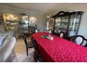 Elegant dining room with glass display cabinets and a large table with red tablecloth at 4111 34Th St E, Bradenton, FL 34208