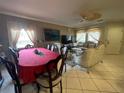 Open-concept living and dining area with tile floors, ceiling fan, and ornate furniture at 4111 34Th St E, Bradenton, FL 34208
