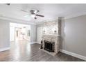 Bright living room with stone fireplace, ceiling fan, gray walls and wood-look tile flooring throughout at 4347 9Th N Ave, St Petersburg, FL 33713
