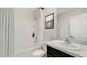 Bright bathroom featuring a shower-tub combo with white tile surround and stylish vanity at 4517 Dusky Dawn Ln, Palmetto, FL 34221