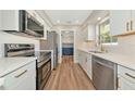 Modern kitchen features white cabinets, stainless steel appliances, and wood-look flooring at 4812 21St W St, Bradenton, FL 34207
