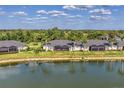 The back of the home displays screened lanais overlooking a serene lake at 5217 Chase Oaks Dr, Sarasota, FL 34241