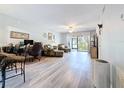 Open living space with a ceiling fan, light wood floors, and sliding glass doors to the outdoors at 5234 Lake Arrowhead Trl # 30, Sarasota, FL 34231
