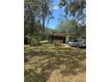 Residential property with a well and lush greenery, and a car parked in the driveway at 6013 Idle A While Cir, Dade City, FL 33523