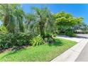 Well-manicured front yard with lush green grass, mature trees, and beautifully landscaped flowerbeds at 6102 Sonesta Ct, Bradenton, FL 34202